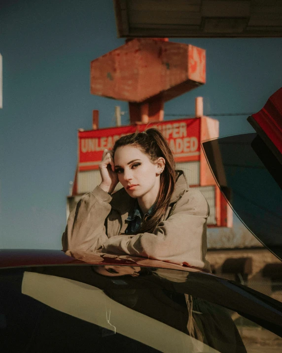 woman leaning on car at stop sign near desert