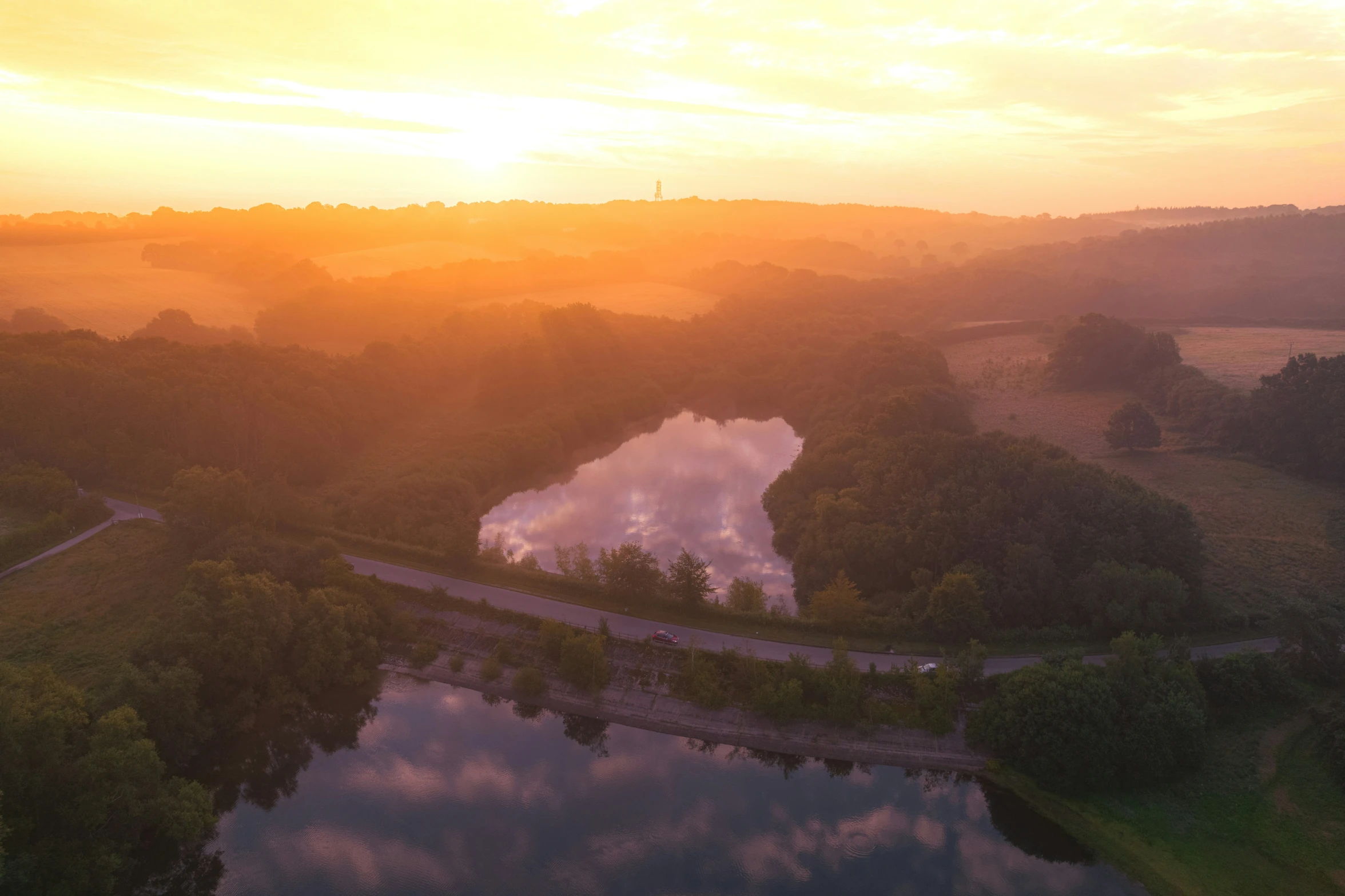 the sun is setting above a small body of water