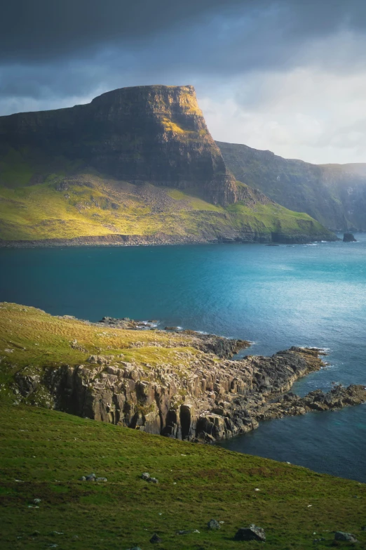 there is a mountain near the ocean that is near some rocks