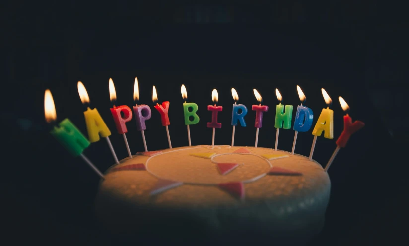 a birthday cake with multicolor candles is shown