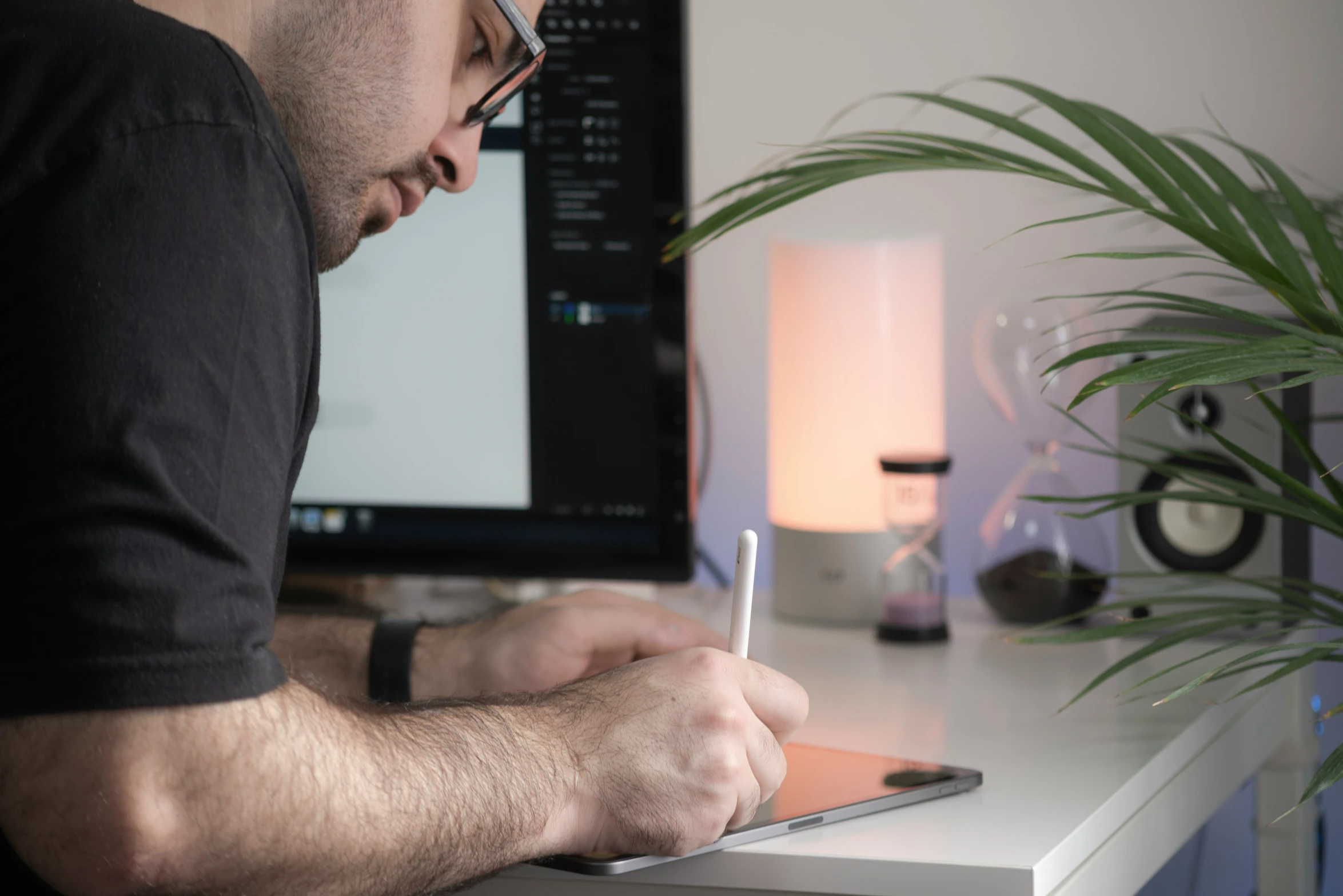 man with computer and a pen working on a notebook