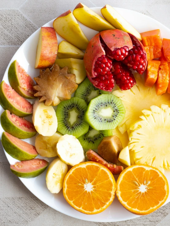 a white plate topped with fruit sliced and sliced oranges