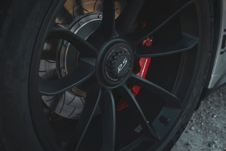 a black vehicle wheel with red accents and spokes