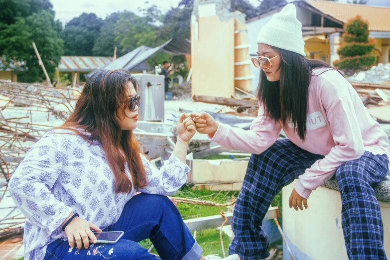 two woman that are sitting down on a roof