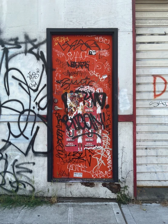 a fire hydrant near a door with graffiti on it