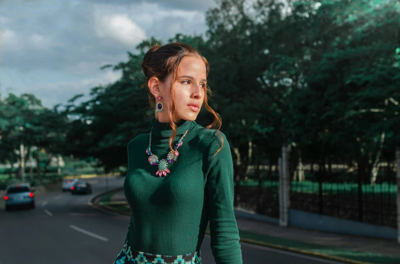 a woman with a green shirt is standing by the street