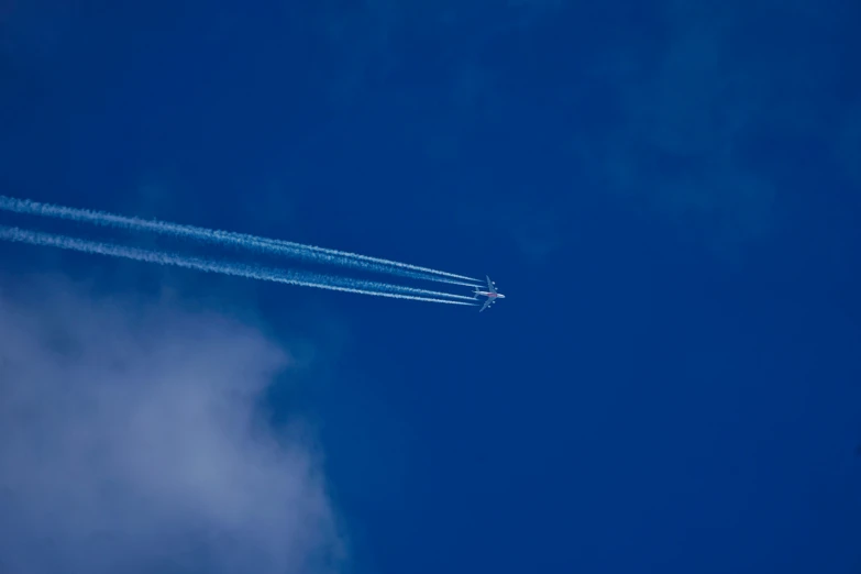 a plane is traveling through the blue sky