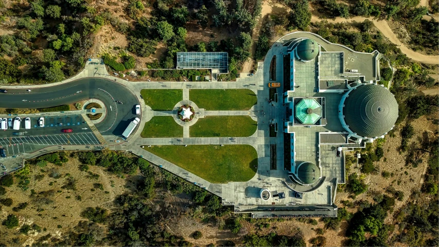 an aerial po of the building that is located in front of trees