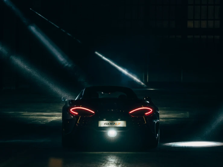 the light on the front of a black sports car is shining bright