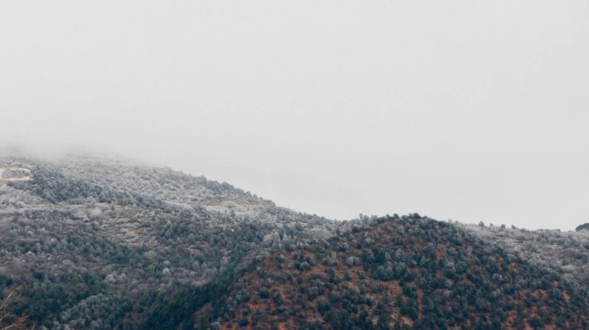 a po taken from the ground of mountains, snow and a plane