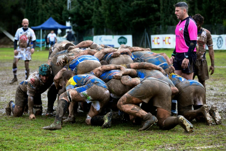 a group of men in mud suits playing soccer