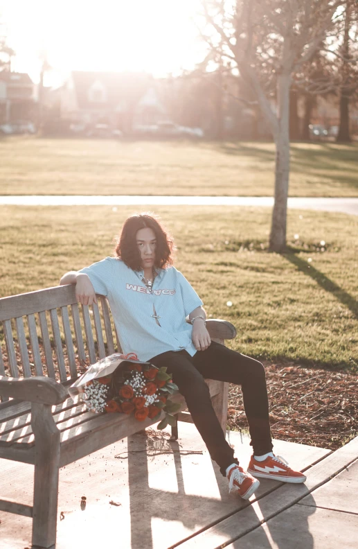 the woman sits on a bench in front of grass