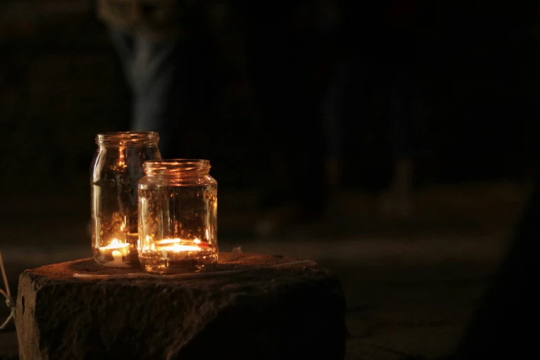 a light in a glass jar sits on top of a table