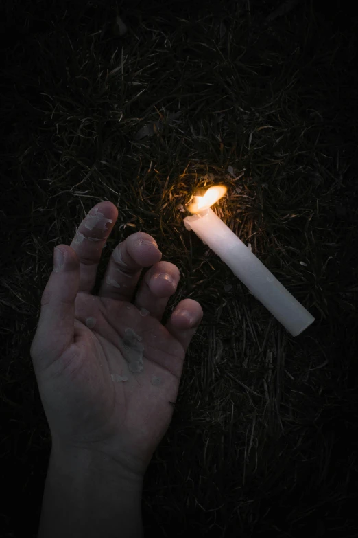 someone has a candle in their hands with a small cigarette