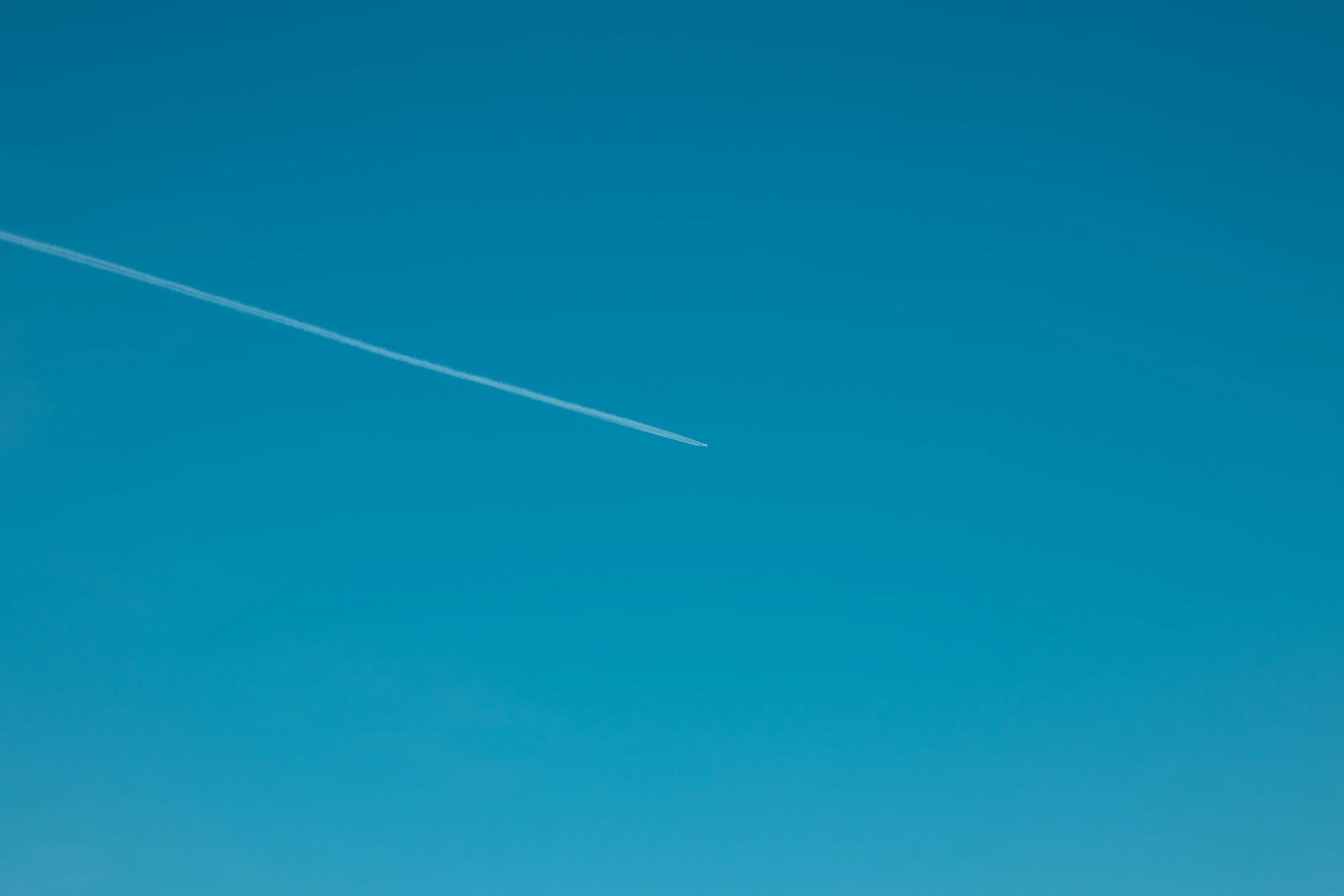 two airplane are flying high in the blue sky