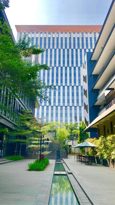 an outdoor water pond sits between two buildings