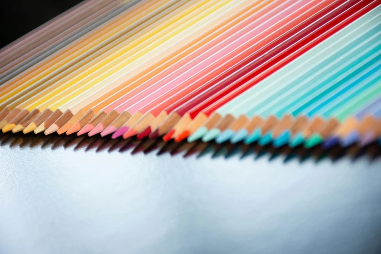 colored pencils sitting in a row on top of a table