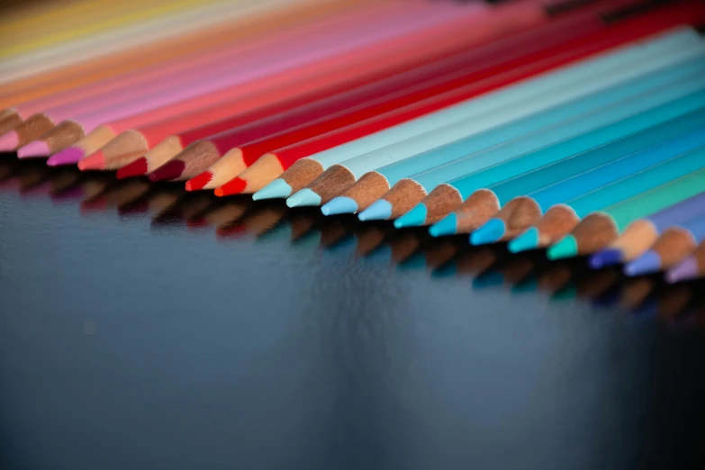 a row of colored pencils arranged next to each other