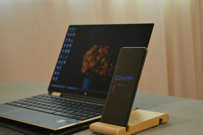 a laptop is displaying a po on the screen and phone holder