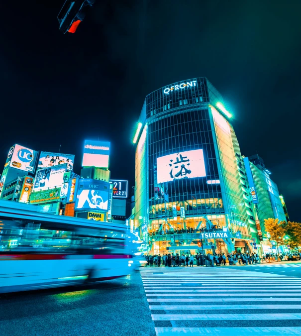 a large glass building in a big city at night