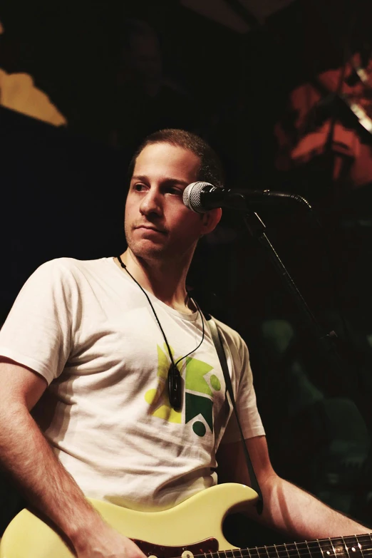 man playing guitar while singing into microphone