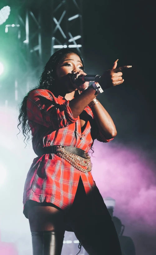 a woman in a plaid shirt holding a microphone
