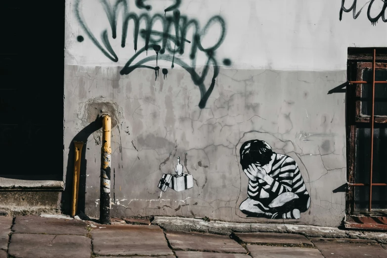 graffiti on the side of a building depicting a person praying