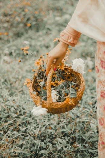 a woman holding a wicker basket with wildflowers