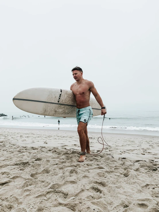 man with surfboard walking on the beach