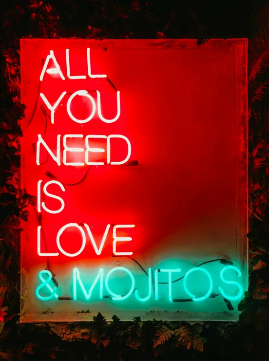 a sign with neon words reading all you need is love and mojitos