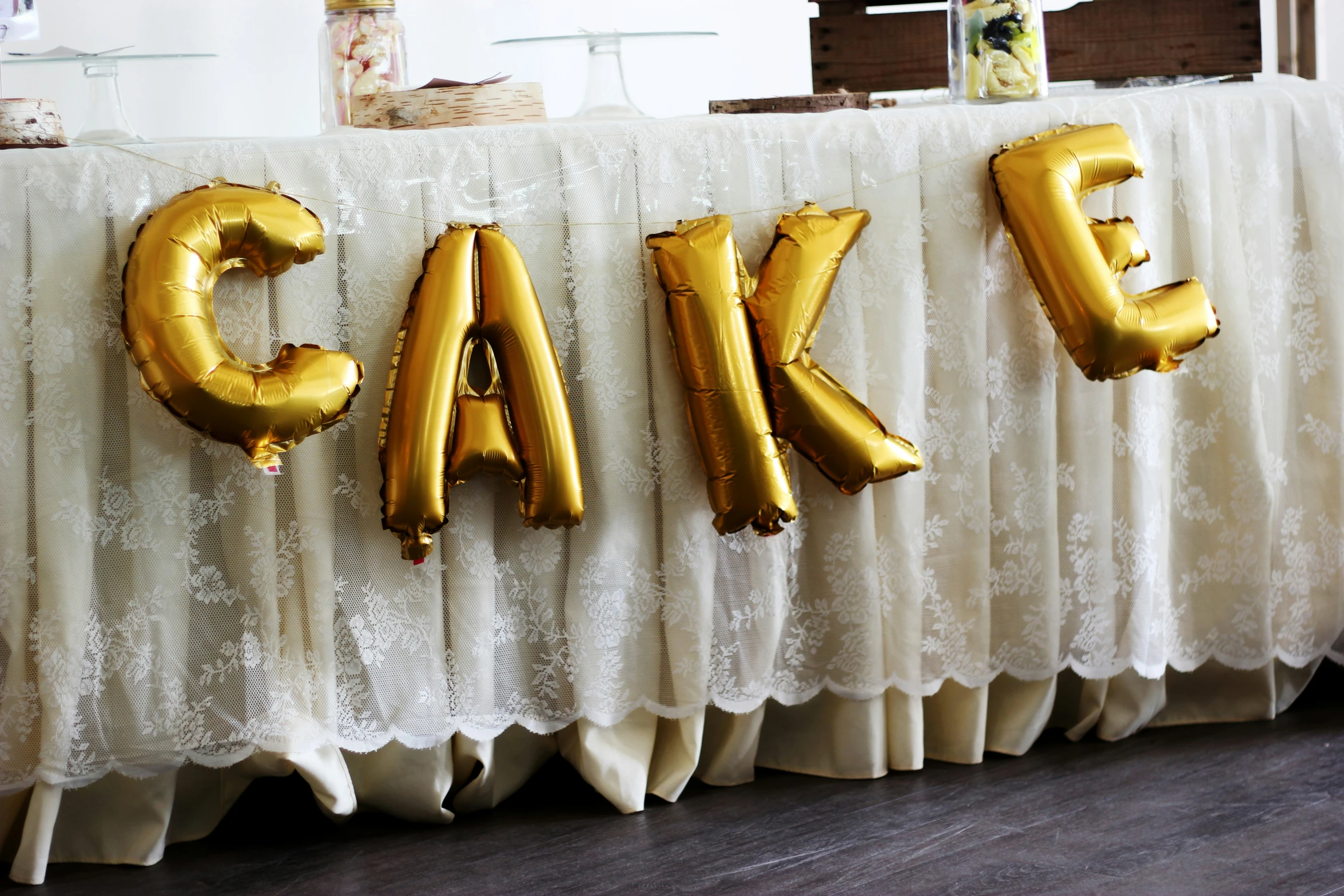 balloons are displayed on the table with the word cake