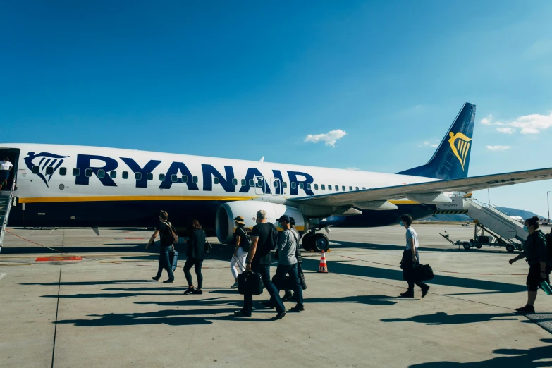 people are exiting the passenger jet at the airport