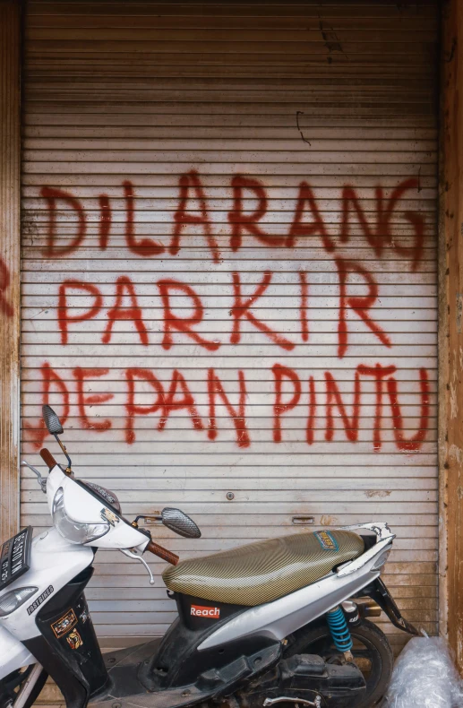 a parked motor cycle sitting next to a garage door