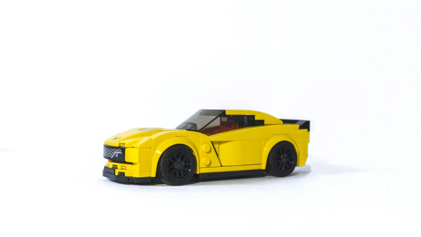 the yellow sports car sits in the white backdrop