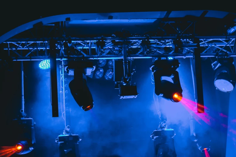 blue lights hang over a set of microphones and music instruments