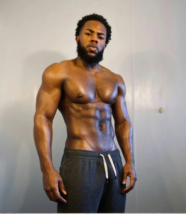 a young man standing with his shirt off posing for the camera