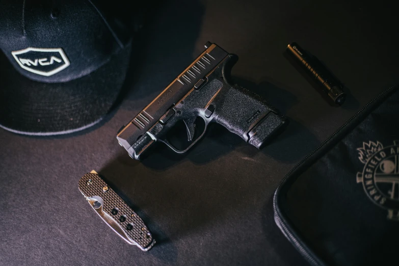 a black hat and some guns on a table