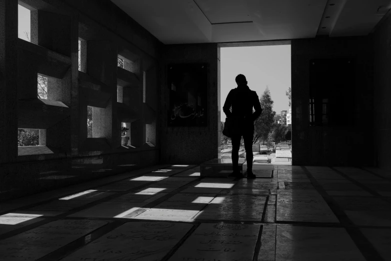 man walking in an empty hallway in the middle of a building