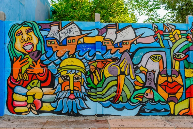 a wall covered in colorful street art with people