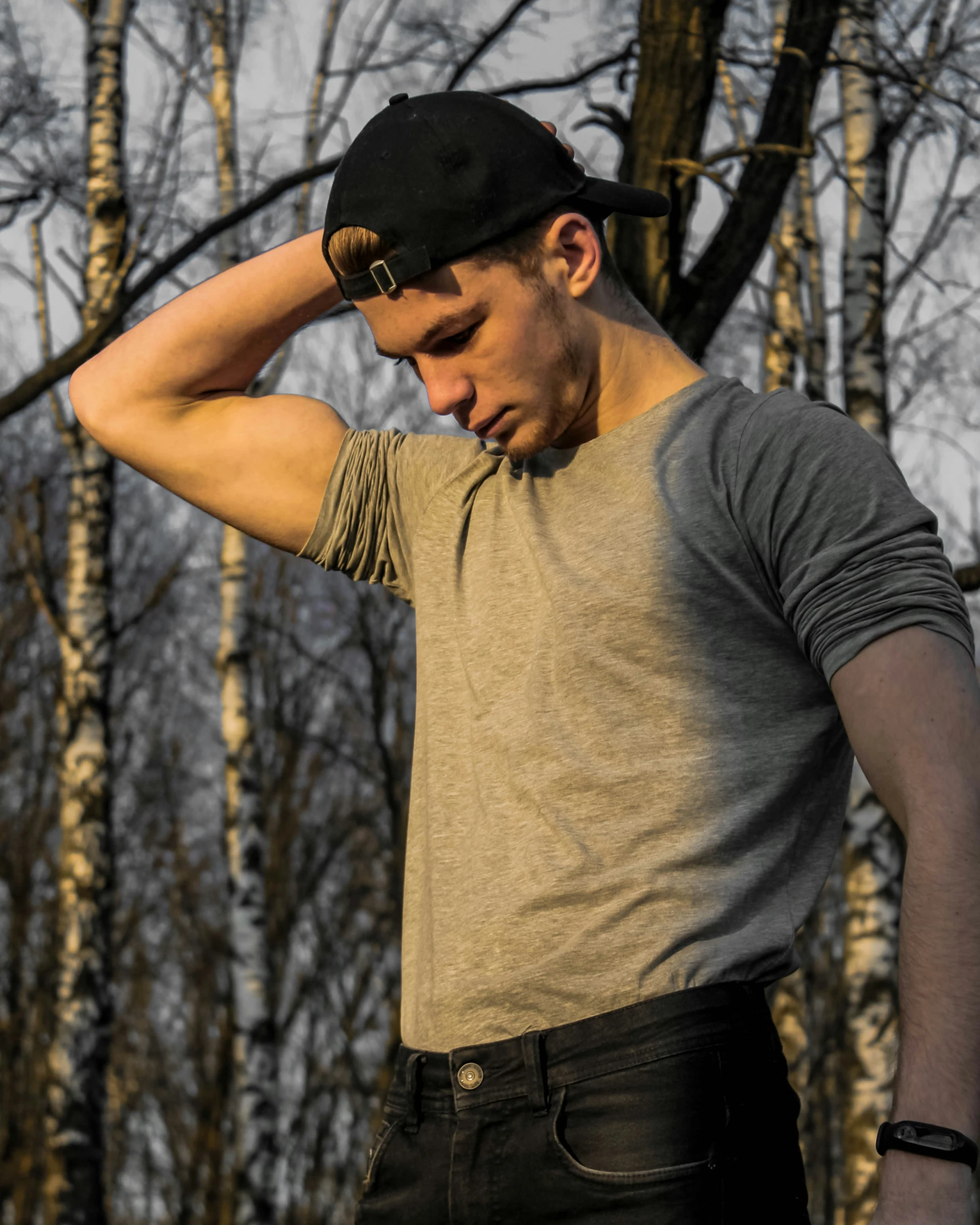 a man poses for a picture in front of some trees