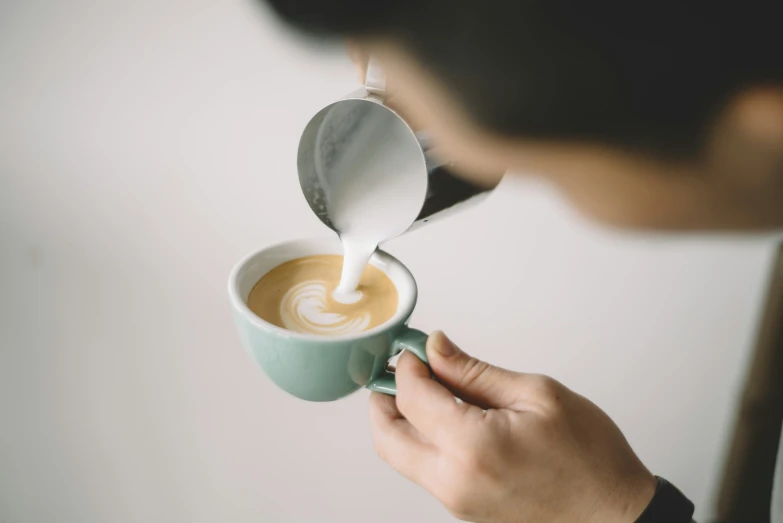 a person holding up a cup of coffee