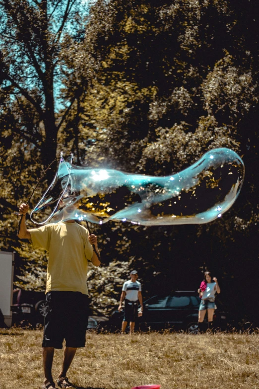 a man and a child playing with a soap bubbles in the park