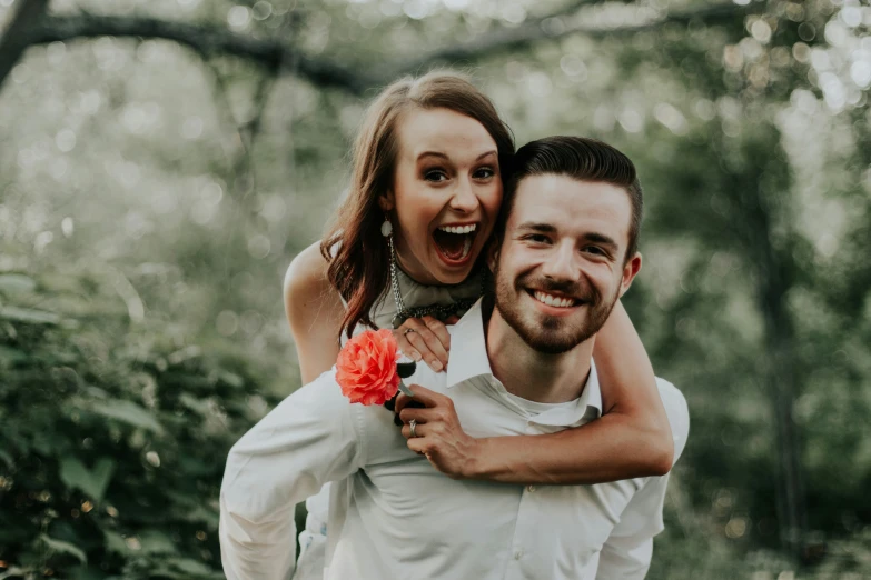 a man holding a woman on the back of his shoulders