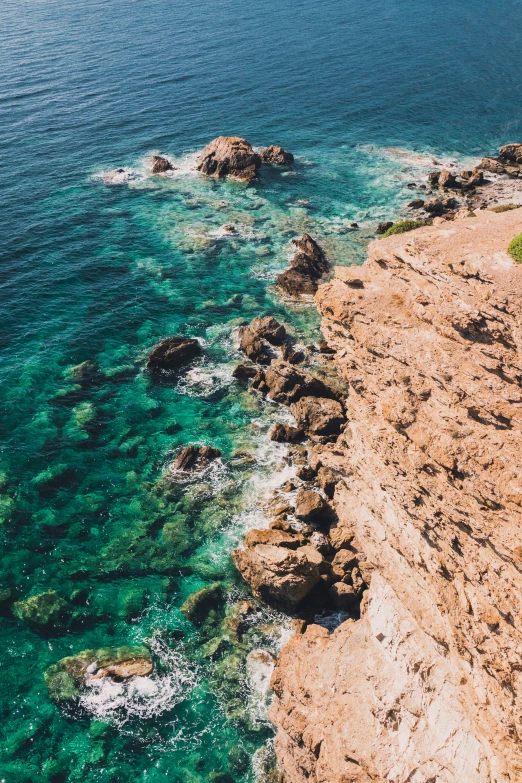 a shoreline at the waters edge with blue water