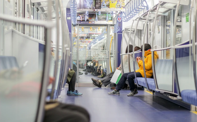 people sitting on a subway train looking inside