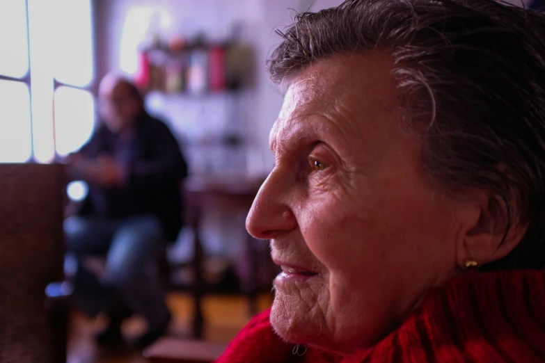 an older woman looking away while standing in the room