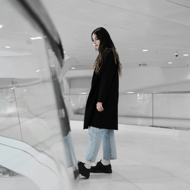 woman standing inside of a building and looking at her reflection