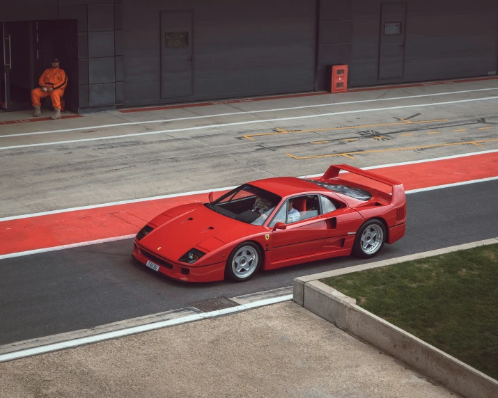 a red sports car is parked in front of an airplane hangar