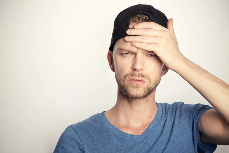 a man holds his hand to the top of his head