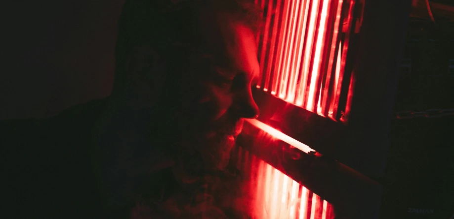 a man sitting in front of a red light